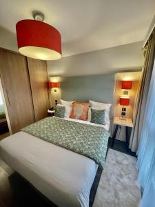 1 dormitorio con 1 cama y luz roja en Residhome Paris-Guyancourt en Guyancourt