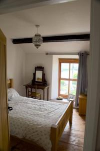 um quarto com uma cama e uma janela em Cwmwl Gwyn Cottage in the heart of the old town em Llantrisant
