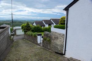 uma vista para uma casa do lado de fora de uma janela em Cwmwl Gwyn Cottage in the heart of the old town em Llantrisant