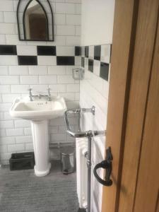 a bathroom with a sink and a white sink at Cwmwl Gwyn Cottage in the heart of the old town in Llantrisant
