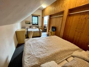 a bedroom with two beds in a room with wooden walls at Penzion & Restaurant Pod Čerťákem in Harrachov