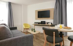 a living room with a couch and a table at Odalys City Angers Centre Gare in Angers