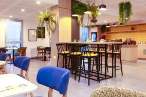 un ristorante con bar con sedie e tavoli di Odalys City Angers Centre Gare ad Angers