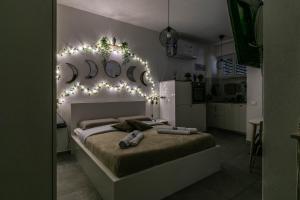 1 dormitorio con 1 cama con luces en la pared en [Eden House SanSiro-Duomo] Netflix & Design, en Milán