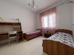 a bedroom with two beds and a chandelier at fatimides appartement in La Marsa