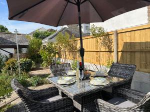 a table and chairs with an umbrella on a patio at Primrose Cottage in Hayle