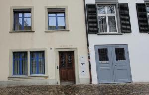 a white building with blue doors and windows at Zimmer in einer privaten Wohnung in Schaffhausen