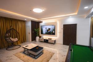 Gerdette Luxury Apartment في لاغوس: غرفة معيشة مع تلفزيون وطاولة بلياردو