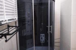 Gerdette Luxury Apartment في لاغوس: دش مع باب زجاجي في الحمام