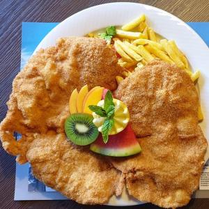 un plato de comida con pollo y papas fritas en Sonnenberg Dormitories en Mürren