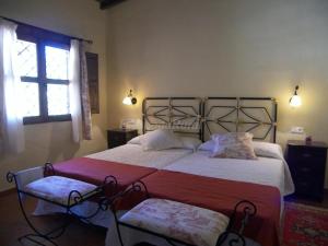 a bedroom with a large bed and a window at Casa Rural Josefina 1 y 2 in Navaconcejo