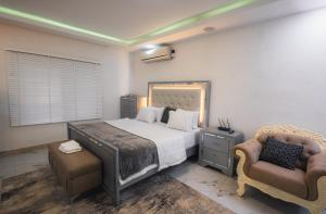 a bedroom with a large bed and a chair at Gerdette Luxury Apartment in Lagos