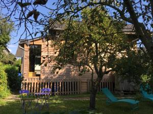 a house with a tree and chairs in the yard at Chalet à la campagne in Clais