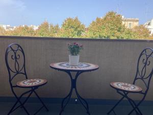 einen Tisch und zwei Stühle mit einer Blumenvase in der Unterkunft B&B Verdi in Lecce
