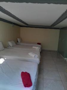 a room with two beds with red towels on them at LINGE'S LODGE EXTENSION in Lusikisiki