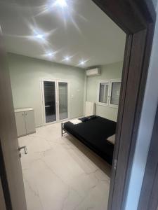 Stratos’ Home في Malakóndas: غرفة نوم بسرير اسود في غرفة
