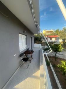 einen Balkon eines Hauses mit einem Tisch und einem Fenster in der Unterkunft Stratos’ Home in Malakóndas