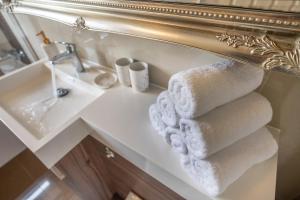 a pile of towels on a bathroom sink in front of a mirror at La Casa Suites Windsor - Two 2-bedroom apartments in Windsor