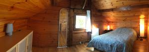 ein Schlafzimmer mit einem Bett in einer Holzhütte in der Unterkunft Chalet à la campagne in Clais
