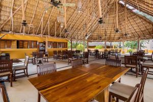 un restaurant avec une grande table et des chaises en bois dans l'établissement Oceanview Oasis in La Cruz, à La Cruz de Huanacaxtle