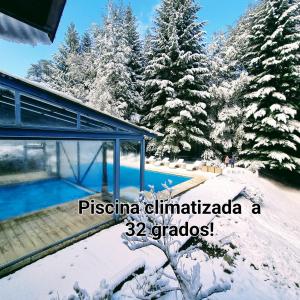 a house with a swimming pool in the snow at Altos Los Pioneros & Spa in Villa La Angostura