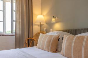 una habitación de hotel con 2 camas y una lámpara en Logis Hôtel La Ferme de Flaran, en Maignaut