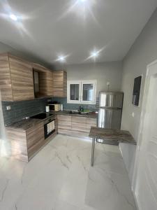 a kitchen with wooden cabinets and a stainless steel refrigerator at Stratos’ Home in Malakóndas