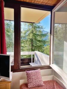 Cette chambre dispose d'une fenêtre offrant une vue sur un arbre. dans l'établissement Studio au pied des pistes avec terrasse, à Vars