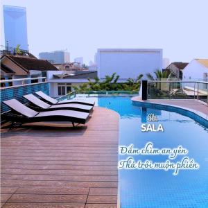 SALA HOTEL HUE في هوى: مسبح مع كراسي جلوس بجانب مبنى
