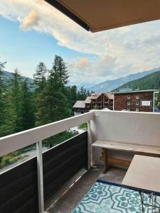 a balcony with a bench and a view of the mountains at Studio au pied des pistes avec terrasse in Vars +18 photos