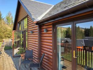 a house with a sliding glass door on a deck at Lochside Lodge in White Bridge