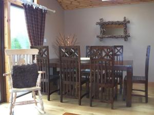 a dining room with a wooden table and chairs at Lochside Lodge in White Bridge