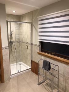 a bathroom with a shower with a glass door at Lochside Lodge in White Bridge