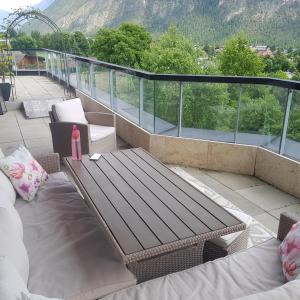 a balcony with a wooden bench and a table at Penthouse in den Bergen in Imst