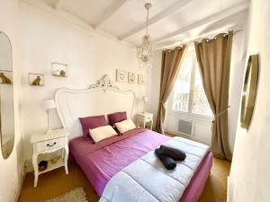 a bedroom with a large bed with purple sheets at Caporizon-Sarlat l'élégance-T2 Plein centre cité médiévale in Sarlat-la-Canéda +20 photos
