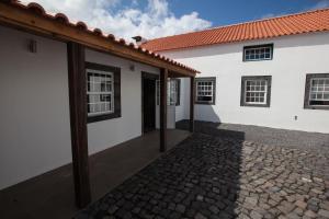 a brick building with a white door and a black and white checkered at Pico da Saudade in Prainha de Baixo