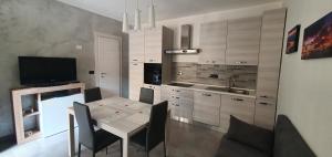 奧爾巴薩諾的住宿－La Maison di Aurora，厨房配有桌椅和电视。
