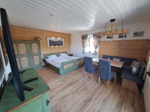 1 dormitorio con 1 cama, mesa y sillas en Lärche 2 - Chiemgaukarte inklusive-, en Inzell