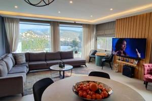uma sala de estar com um sofá e uma televisão em Bodrum merkez'de Havuzlu, Saunalı, müstakil villa em Bodrum City