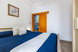 トッレ・カンネにあるAppartamento Venere - MyHo Casaのベッドルーム1室(青と白のベッド1台、ドア付)