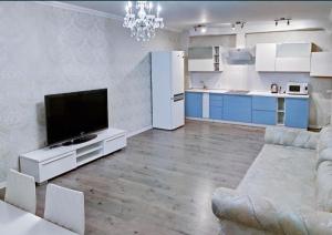 un soggiorno con TV e cucina di 2к квартира на Академгородке a Kiev