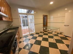eine Küche mit einer Tischtennisplatte auf einem karierten Boden in der Unterkunft MAR i MONTAÑA en Cullera Villa Juani in Cullera