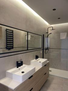 Baño con 2 lavabos y espejo en Apartamenty Parkowa - Kamień Śląski, en Kamień Śląski