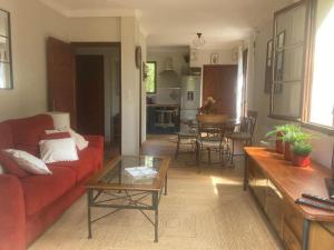 a living room with a red couch and a table at Charmant T2 dans chalet familial in Valdeblore
