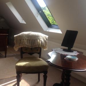 Duneton的住宿－The Old Smithy，一间配备有椅子和一张桌子及一台电脑的房间