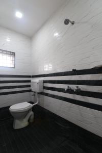 a bathroom with a toilet and black and white stripes at HOTEL VALLABHA RESIDENSY in Rājahmundry