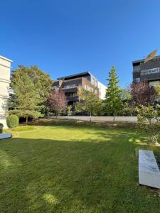 un parque con un banco en el césped en Residhome Paris-Guyancourt, en Guyancourt