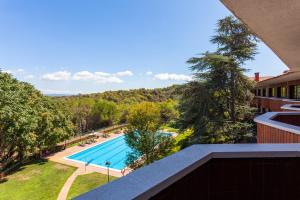 a view of a swimming pool from a balcony at Checkin Montserrat in Collbató