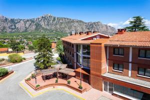 une vue aérienne sur un bâtiment avec des montagnes en arrière-plan dans l'établissement Checkin Montserrat, à Collbató