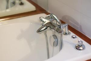 a bathroom sink with a chrome water faucet at Refuge centre ville avec parking in Annecy +27 photos